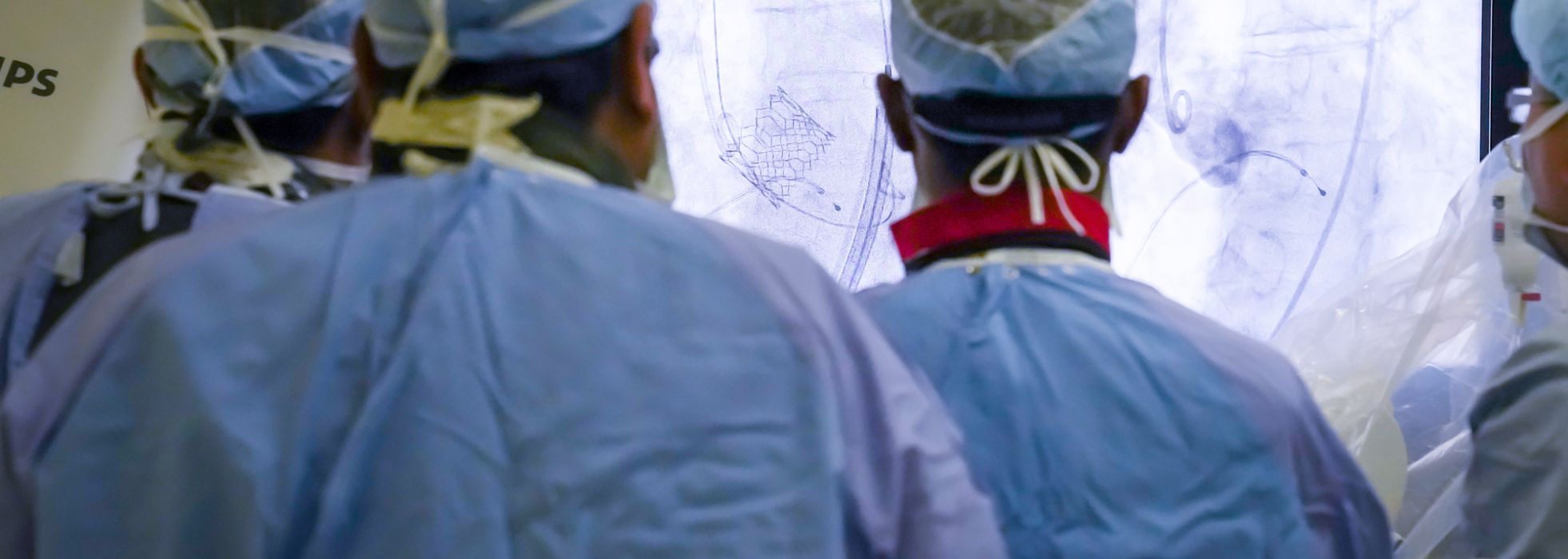 Interventional cardiologists looking at screen int the cath lab