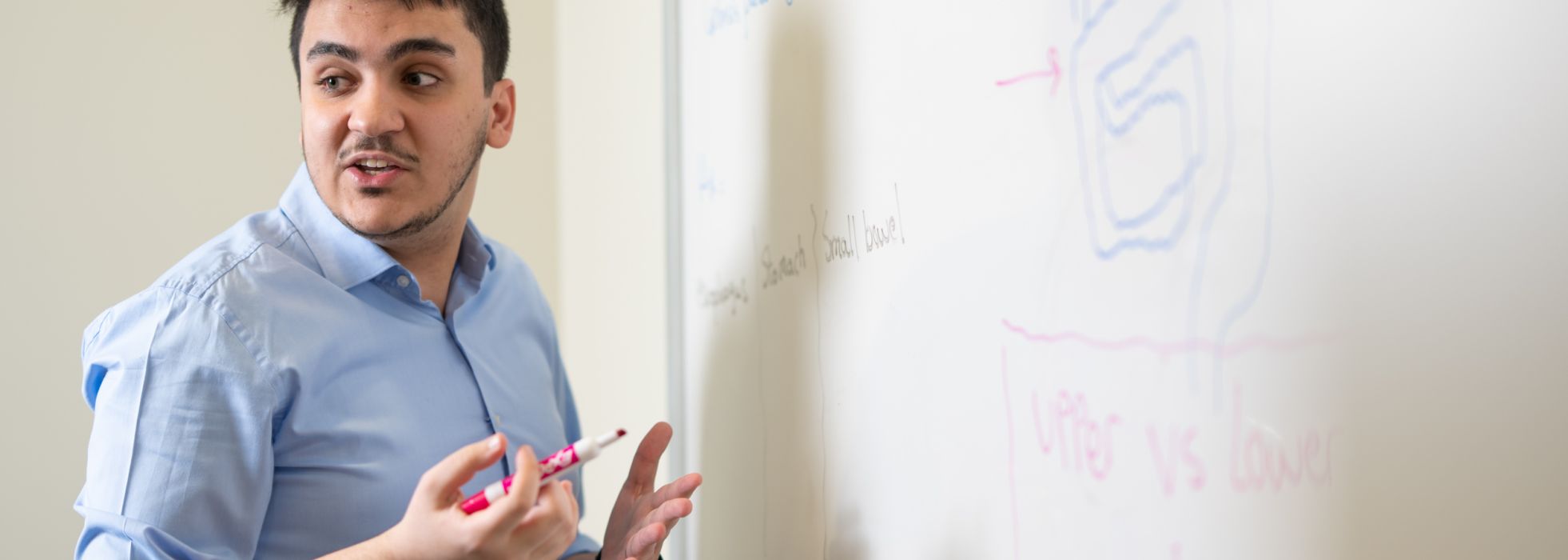 Chief resident and TEACH pathway member Mazen Almasry teaches at a whiteboard.