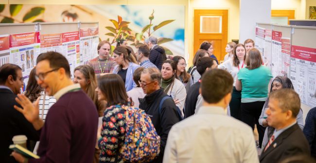 Participants mingle at the 2026 DOM Education Day poster presentation.