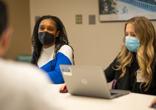 Dr. Sancia Ferguson and pharmacist Britney Youngchild sitting at a table during a Rheumatology conference
