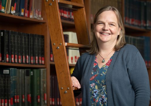 Portrait of Dr. Heidi Twedt in front of a ladder in the medical library