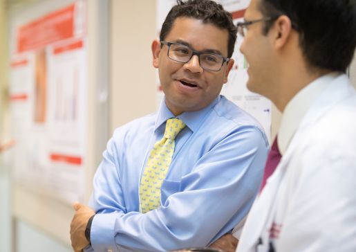 Dr. Caldera speaking with another man in front of research posters
