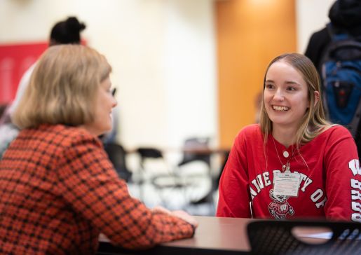 Two women speak to each other across a table