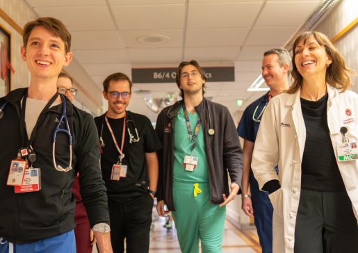 A group of doctors walking down a hospital hallway towards the camera
